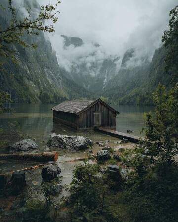fog rolling down the mountains surrounding obersee lake, berchtesgaden national park, bavaria, germany.