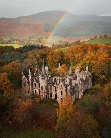 rainbow over the desolate ruins of the dunalastair mansion, perthshire, the scottish highlands.