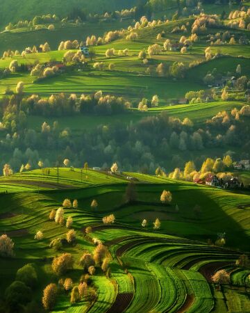 the rolling green hills of podpoľanie dotted with farmhouses, slovakia.