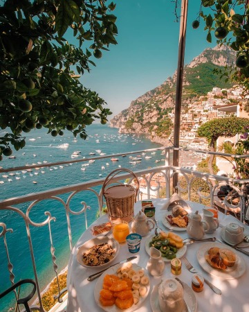 breakfast on a balcony with views of positano on the amalfi coast and the boats on the gulf of salerno, campania, italy.