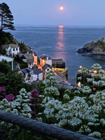 moon over the english channel seen from the fishing village of polperro, cornwall, england.