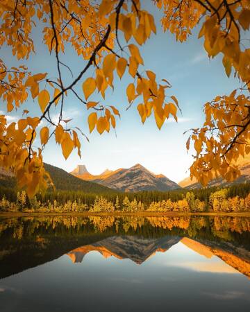 mountains reflected in wedge pond of the canadian rockies, kananaskis country west of calgary, alberta, canada.