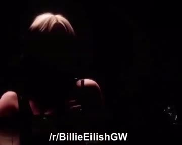 billie eilish taking her top of at a live show